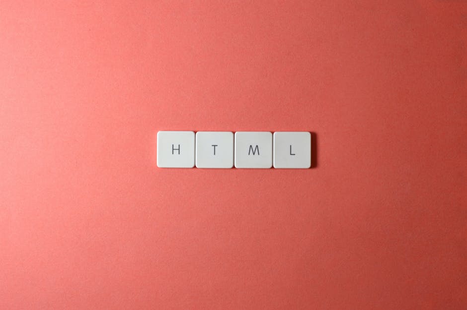 Close-up of four white rectangular tiles with black letters spelling 'HTML' arranged in a horizontal line on a pink background, with the background left plain and evenly lit, capturing a minimalistic 